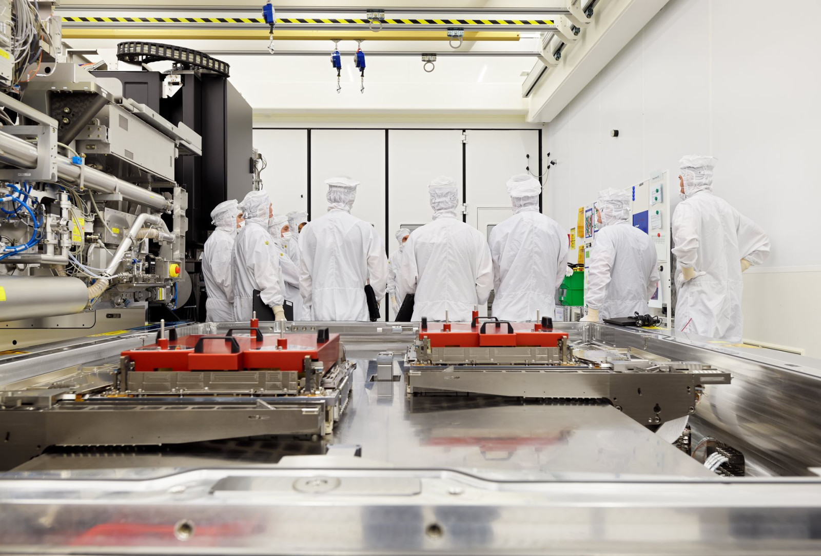 ASML engineers assembling an extreme ultraviolet lithography system inside a semiconductor cleanroom